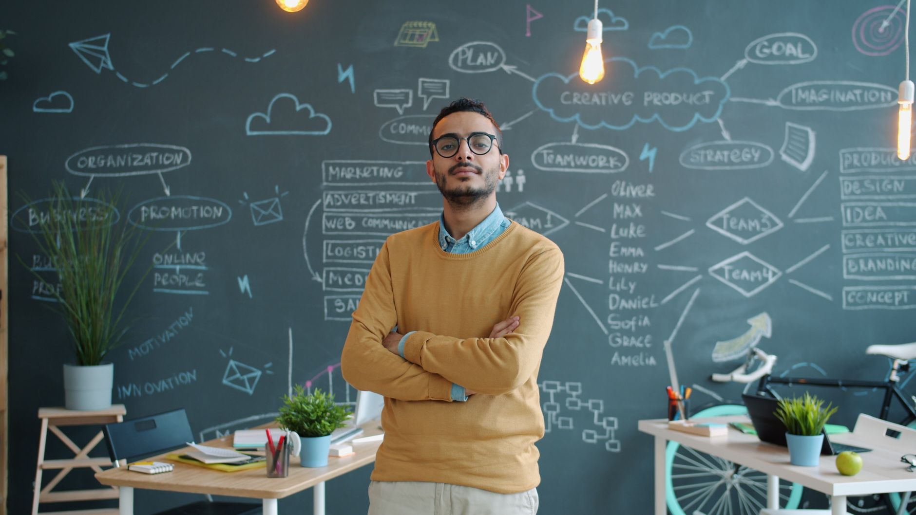 Entrepreneur standing confidently in a modern office with a creative chalkboard background.